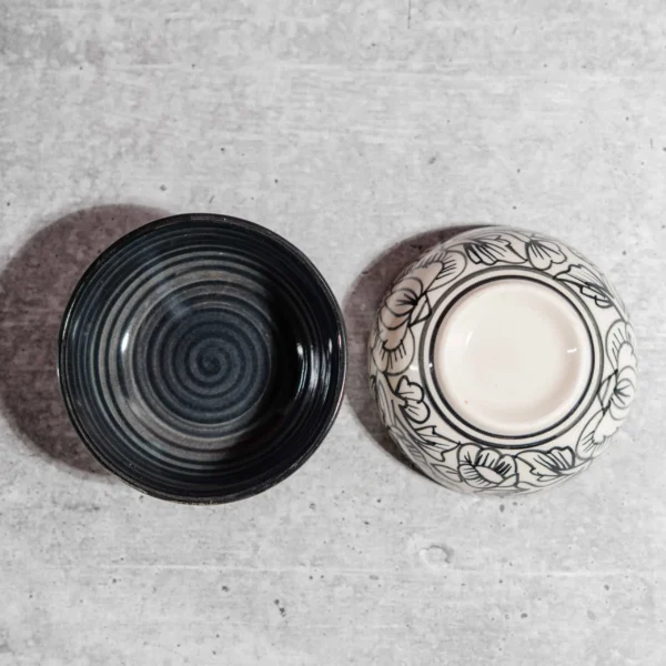 Monarca Ceramic Katori Bowls – Set of 2 by Harmiche. Hand-painted black floral design, microwave & dishwasher safe. Perfect for curries, dal & desserts.